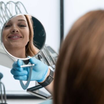 in-the-dental-chair-the-patient-holds-the-mirror-2024-10-17-02-44-53-utc patient after all-on-4 dental implant in turkey
