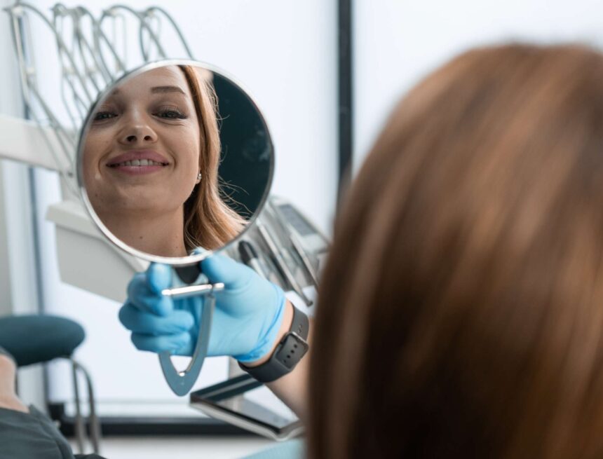 in-the-dental-chair-the-patient-holds-the-mirror-2024-10-17-02-44-53-utc patient after all-on-4 dental implant in turkey